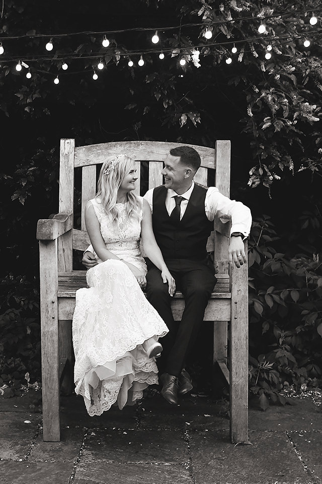 bride and groom sitting in the big chair at the ravenswood in sussex