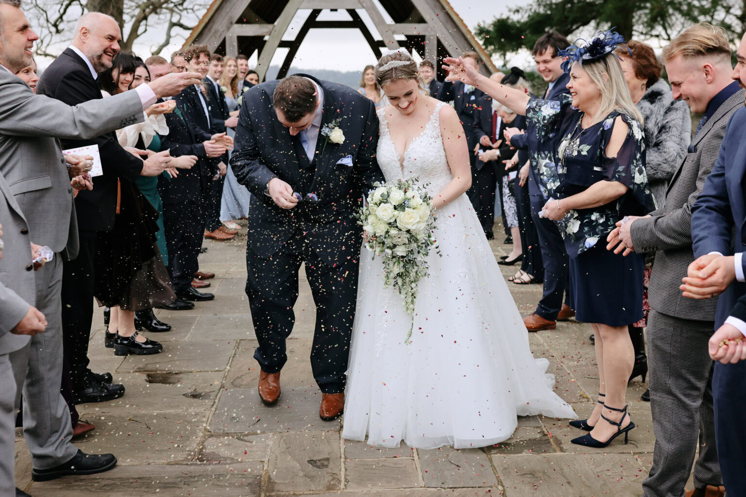 Guests throwing confetti outside Highley Manor after the winter ceremony