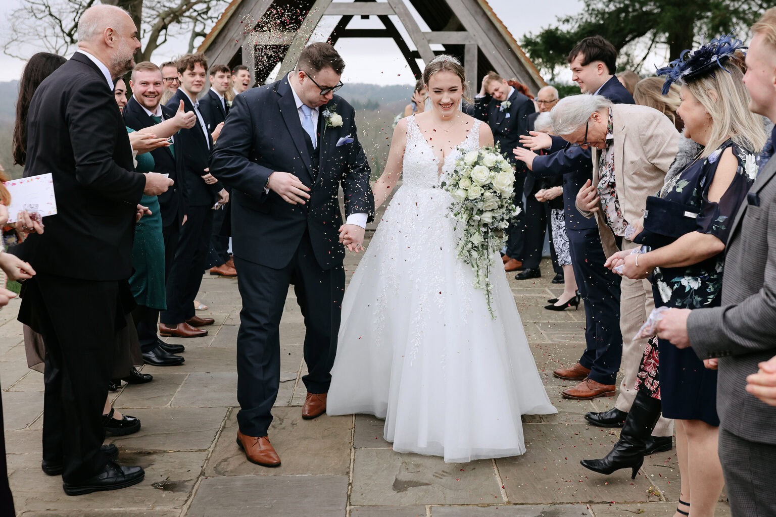 Guests throwing confetti outside Highley Manor after the winter ceremony