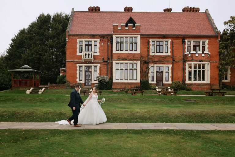 Bride and groom walking through the grounds of Highley Manor in February